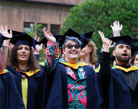 graduates waving to camera